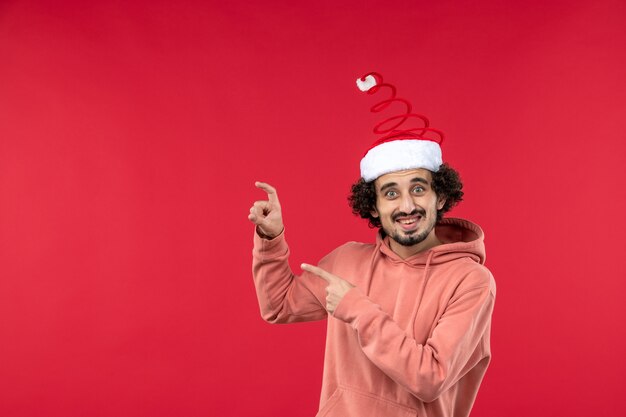 Front view of young man with smiling expression on a red wall