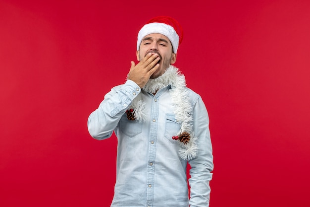 Free Photo front view of young man yawning on red wall