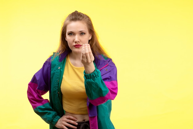 A front view young modern woman in yellow shirt black trousers and colorful jacket posing asking question