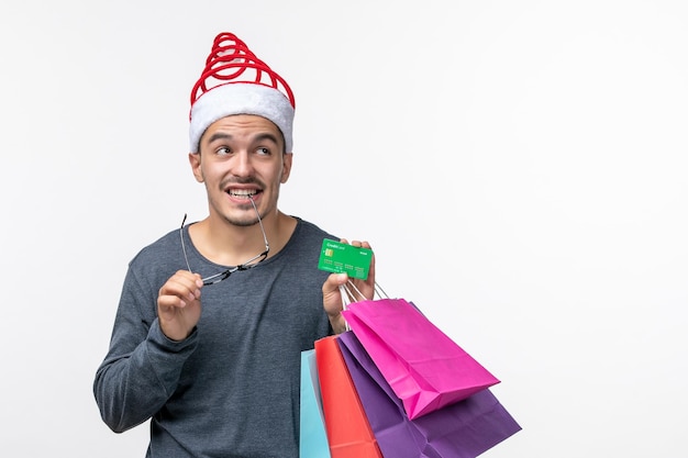 Front view of young person with holiday packages on white wall