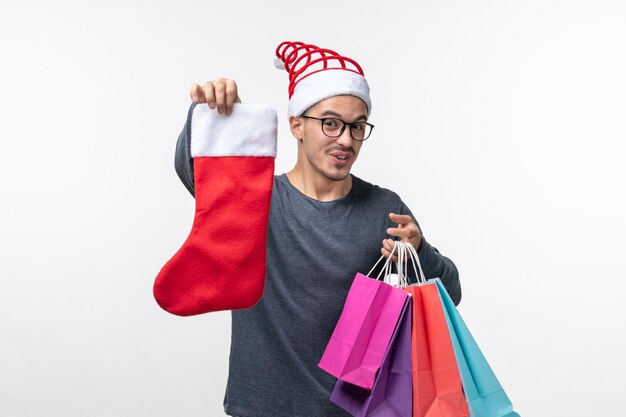 Front view of young person with packages and sock on white wall