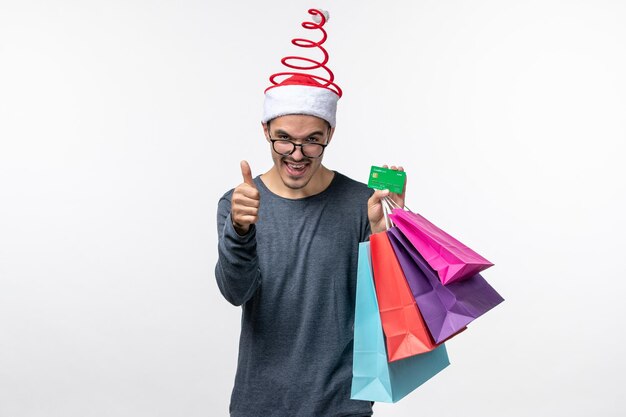 Front view of young person with packages on white wall