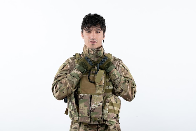 Free photo front view of young soldier in military uniform on white wall