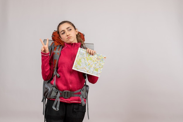 Front view young traveller with big backpack holding map making victory sign