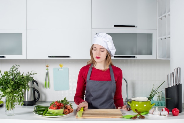 Free photo front view young woman in apron taking knife