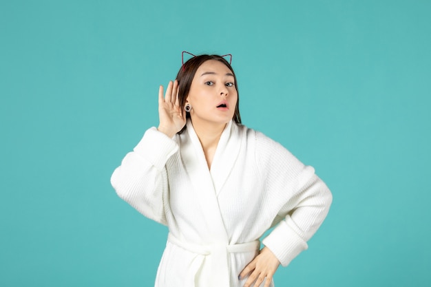 front view of young woman in bathrobe on blue wall