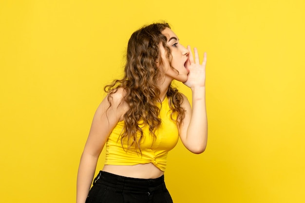 Free Photo front view of young woman calling on yellow wall