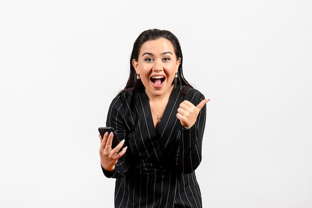 Front view young woman in dark strict suit holding phone on white background woman lady fashion worker job beauty