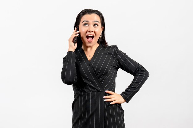 Front view young woman in dark strict suit talking on phone on the white background woman lady fashion worker job beauty