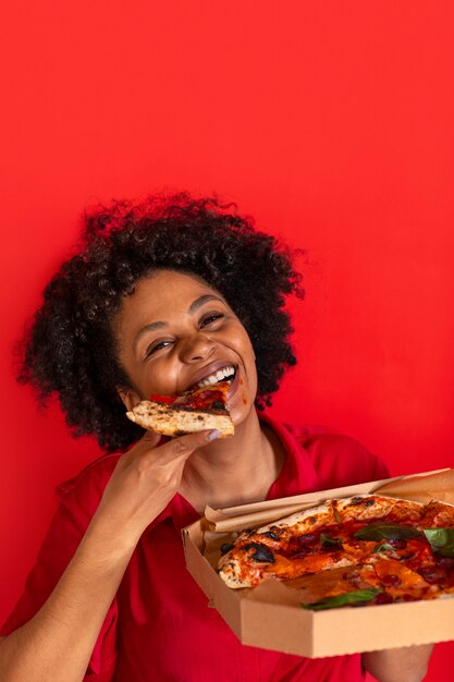 Front view young woman eating delicious pizza