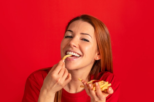 Free Photo front view young woman eating fries