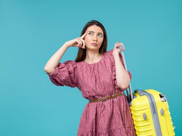 Front view young woman going in vacation with her yellow bag on blue background journey summer woman human trip sea