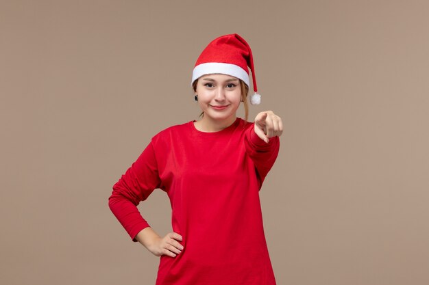 Front view of young woman pointing on brown