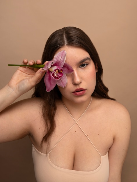 Free photo front view young woman posing with flower