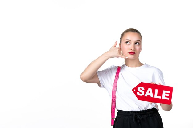 Front view young woman posing with measure tape and sale nameplate on a white background losing measuring slimming shopping mall torso hip skin body waist