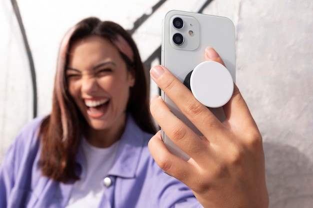 Free photo front view young woman using popsocket