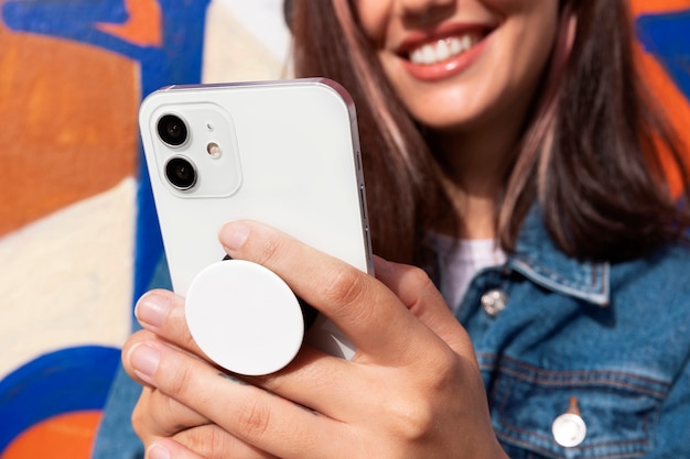 Free photo front view young woman using popsocket