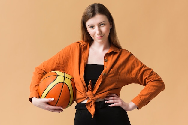 Free Photo front view young woman with basketball ball