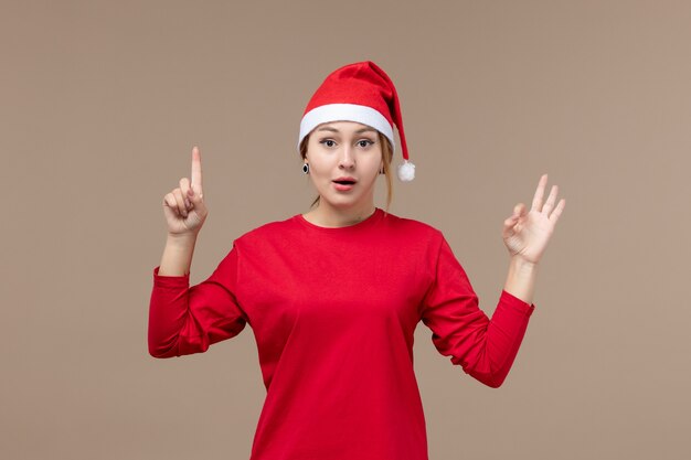 Front view of young woman with excited face on brown