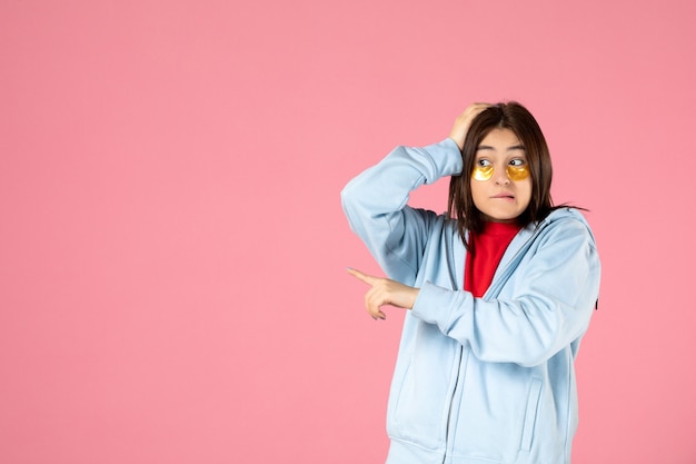 Free Photo front view of young woman with eye patches on pink wall