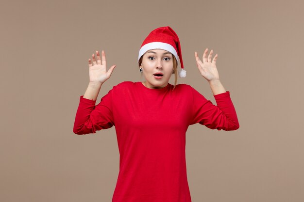 Front view of young woman with surprised face on brown