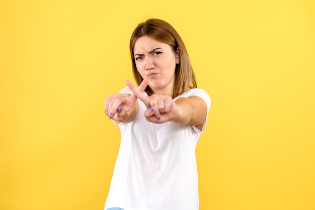 Front view of young woman on yellow wall