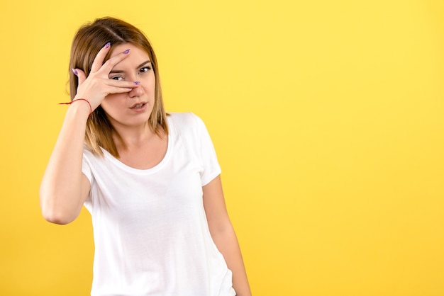 Front view of young woman on yellow wall