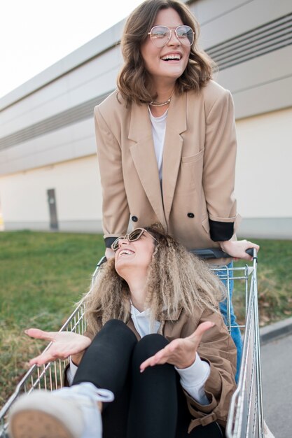 Front view young women playing with shopping cart