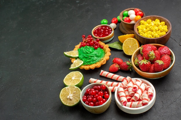 Free photo front view yummy cake with fruits and candies