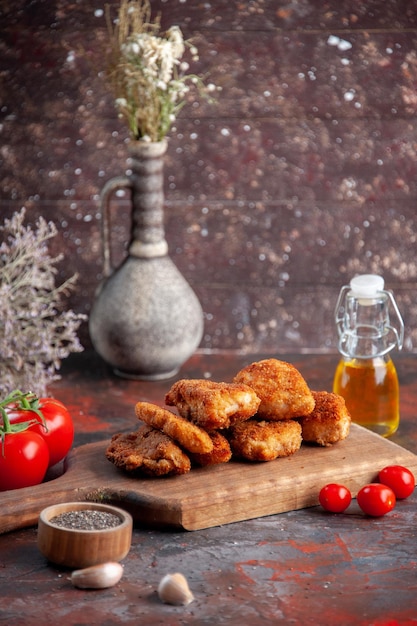 Front view yummy chicken wings on cutting board with tomatoes dark background burger food meal sandwich lunch salad horizontal