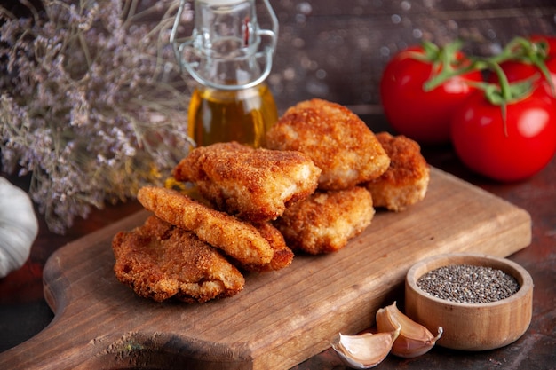 Front view yummy chicken wings on cutting board with tomatoes dark background dinner sandwich meal burger salad lunch