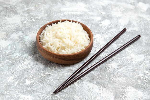 Front view yummy cooked rice inside brown plate on white space