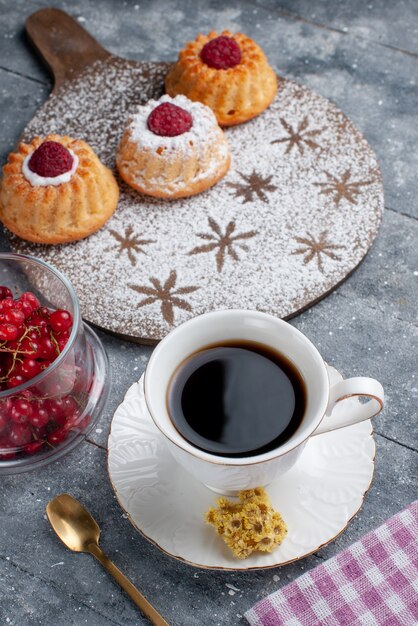 Front view yummy d cakes with cup of coffee and fresh red cranberries on the grey desk sweet fruit