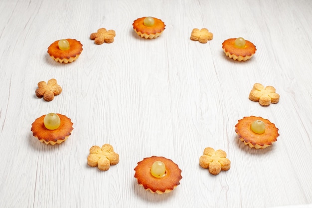 Front view yummy little cakes lined with cookies on white background dessert biscuit tea cake pie sweet cookies