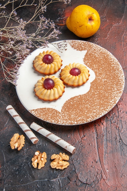 Front view yummy little cookies inside plate on dark floor cake sweet biscuit sugar