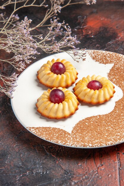 Front view yummy little cookies inside plate on dark table cake sweet biscuits