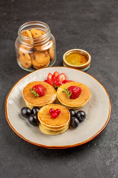 Front view yummy pancakes with fruits on dark surface fruit pie sweet cake