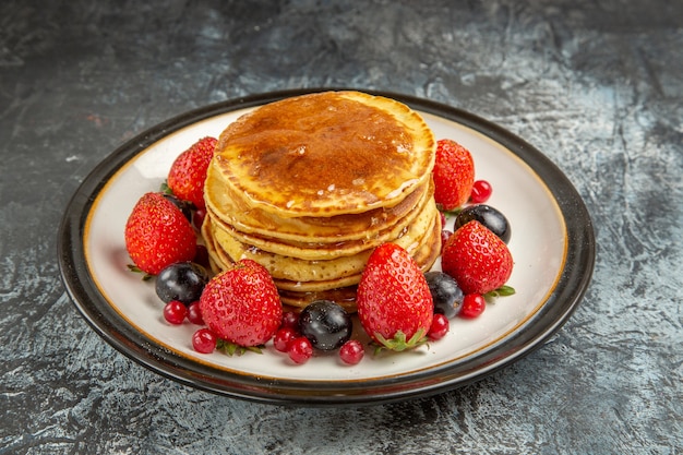 Front view yummy pancakes with fruits and honey on a light surface breakfast sweet fruit