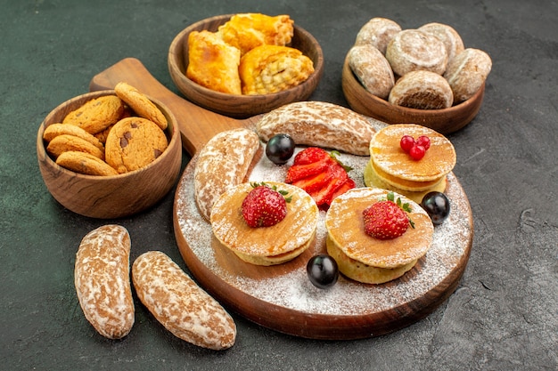 Front view yummy pancakes with fruits and sweet cakes on dark surface sweet cake dessert