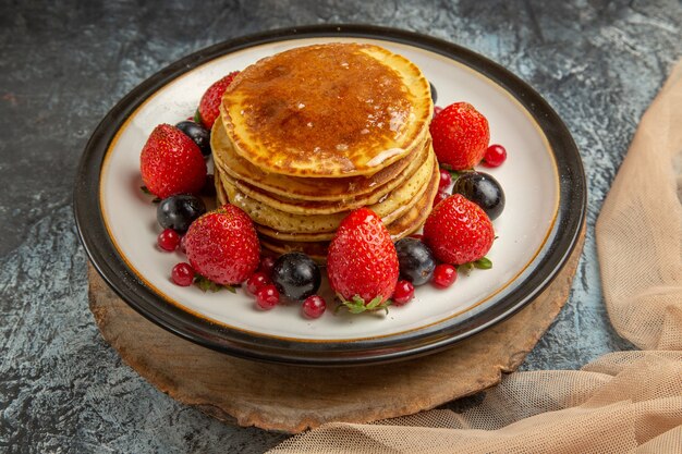 Front view yummy pancakes with honey and fruits on light surface sweet fruit milk