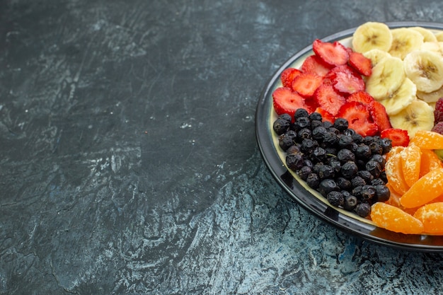 Front view yummy sliced fruits inside plate on gray exotic color healthy life photo mellow tree ripe shade