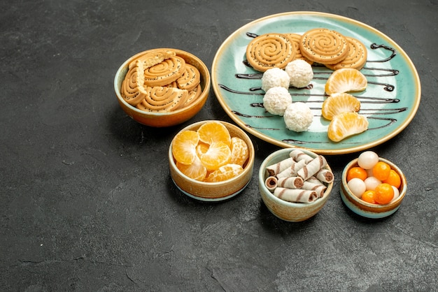 Front view yummy sugar cookies with candies on dark-grey table biscuit cookie cake