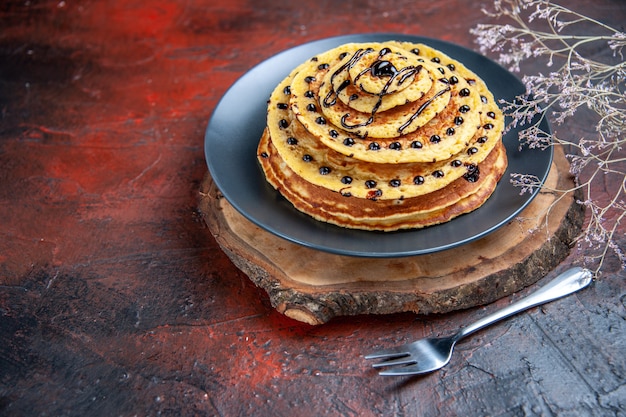 Front view yummy sweet pancakes with choco icing on dark background c