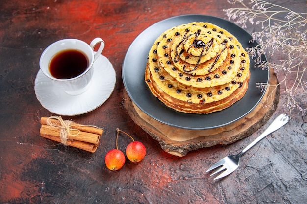 Front view yummy sweet pancakes with tea on dark background