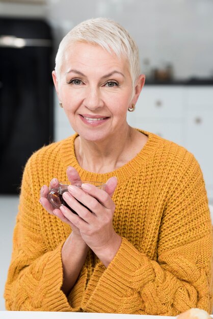 Front woman posing and smiling while holding coffee cup