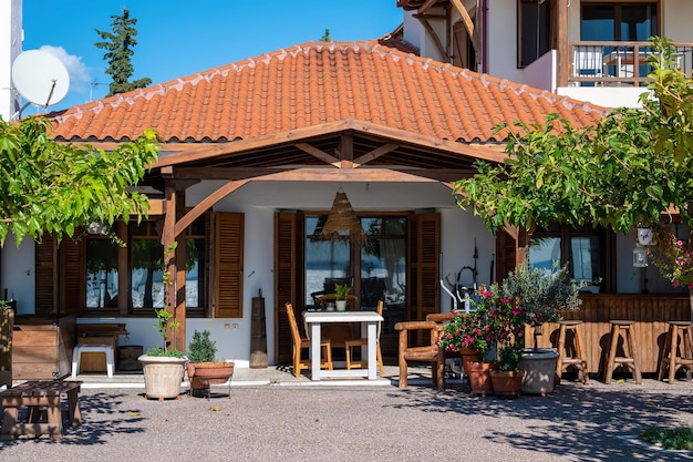 Front yard and terrace of an restaurant made in national style with greenery, chairs ad tables in Nikiti, Greece