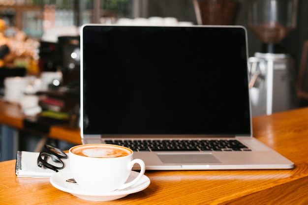 Frontview laptop and coffee on wooden surface