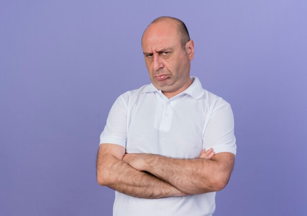 frowning mature businessman standing with closed posture