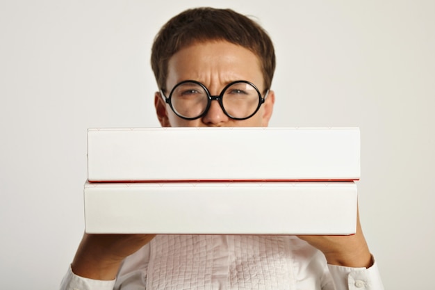 Frowning young woman student in round glasses holds two big folders with educational plan for new year in university Focus on folders