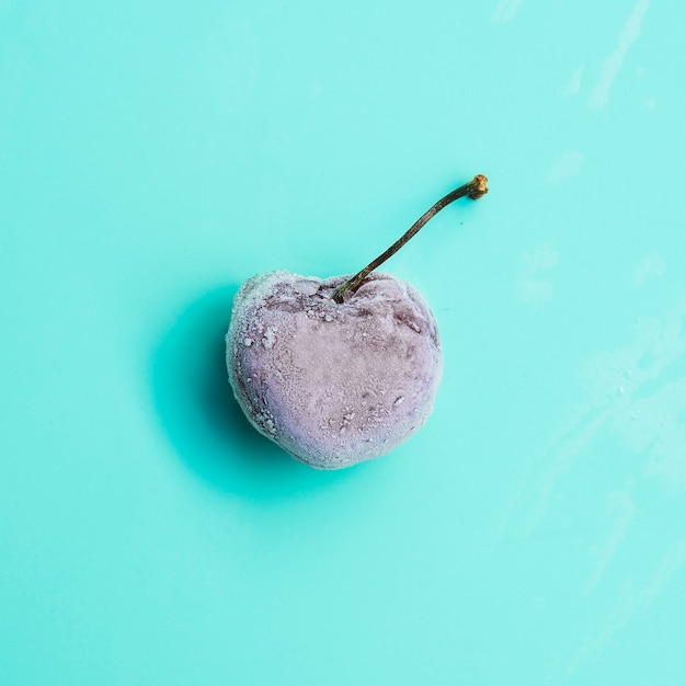 Free photo frozen cherry on turquoise background